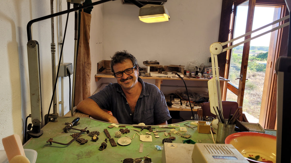 Lorenzo Pepe smiling at his jeweller's bench in his studio on Formentera