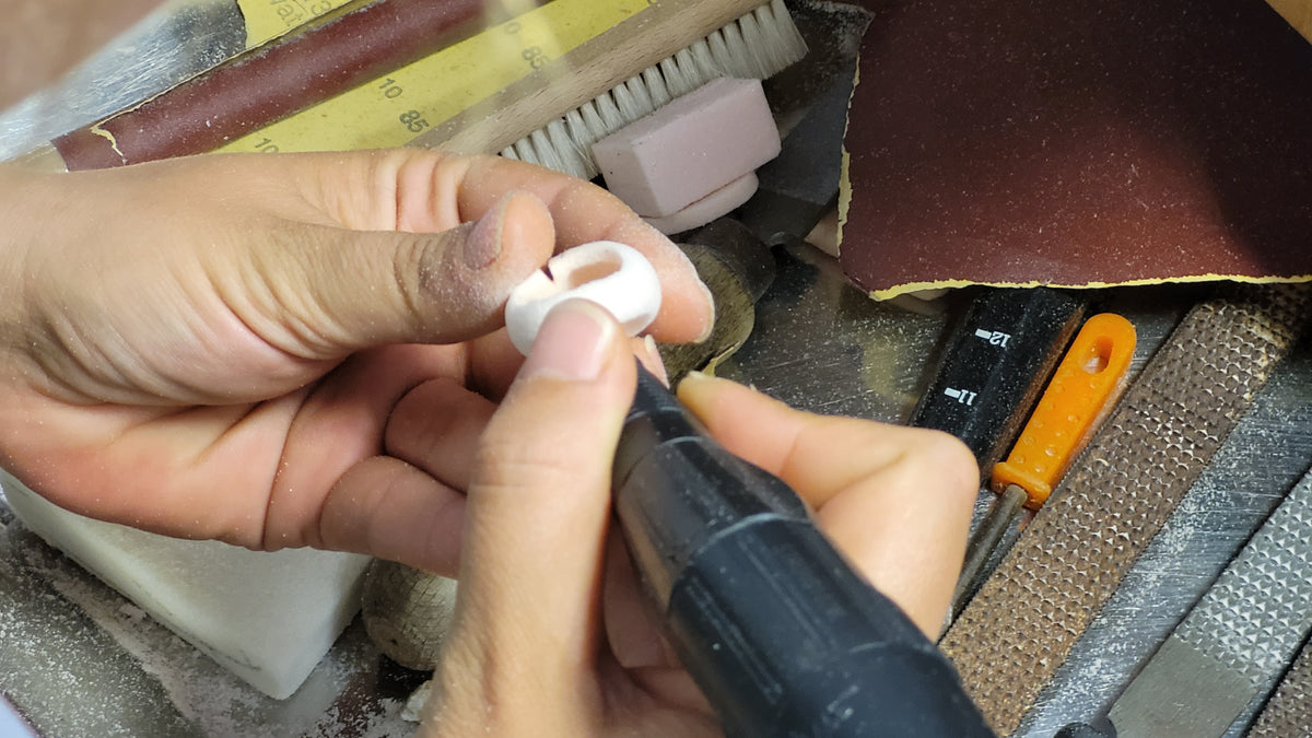Hands carving a foam model for a ring with a flex-shaft