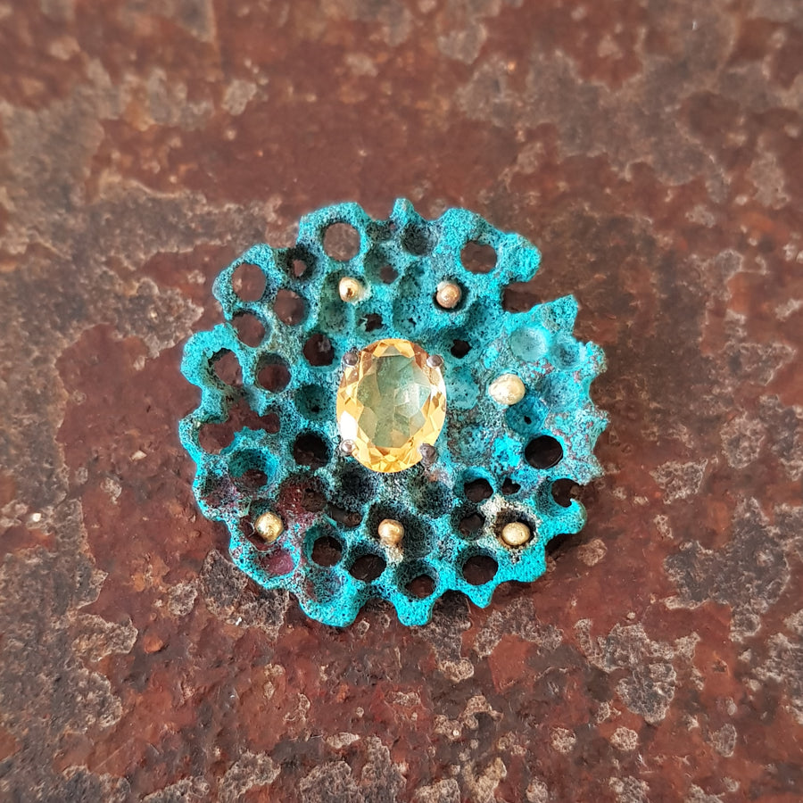 A turquoise patina pendant set with a citrine